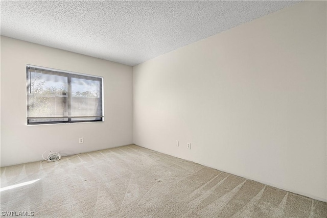 carpeted empty room featuring a textured ceiling