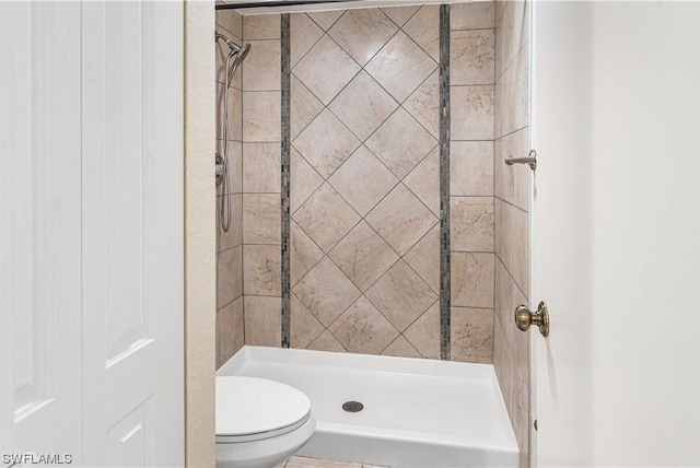 bathroom with tiled shower and toilet