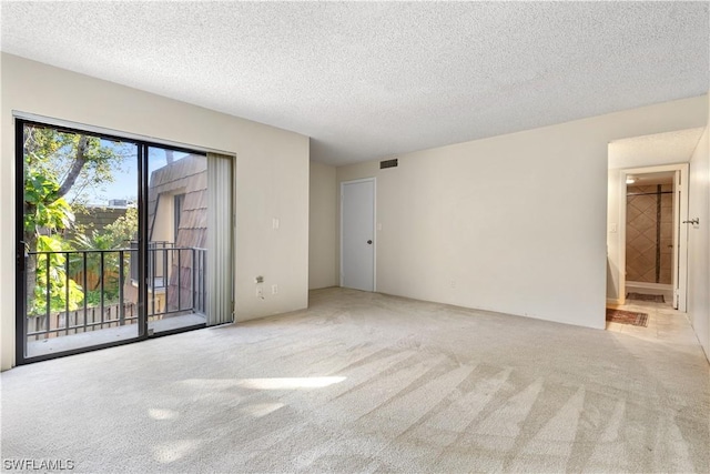 carpeted spare room with a textured ceiling