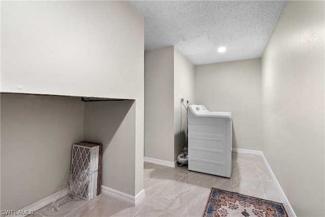 clothes washing area with washer / dryer and a textured ceiling