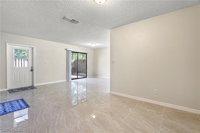 unfurnished room with a textured ceiling