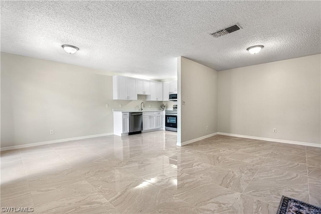 unfurnished living room with sink and a textured ceiling