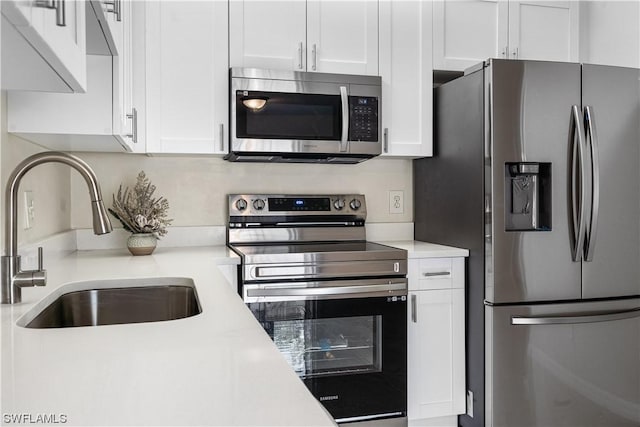 kitchen featuring white cabinets, stainless steel appliances, and sink