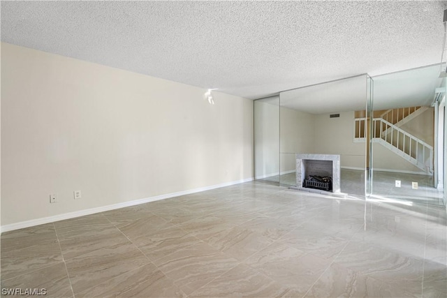 unfurnished living room featuring a fireplace and a textured ceiling