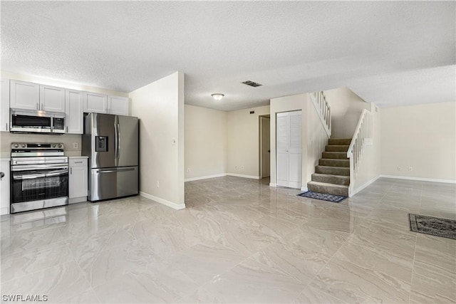 kitchen with white cabinetry, a textured ceiling, and appliances with stainless steel finishes