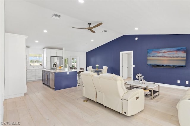 living room featuring ceiling fan, light wood-type flooring, and lofted ceiling