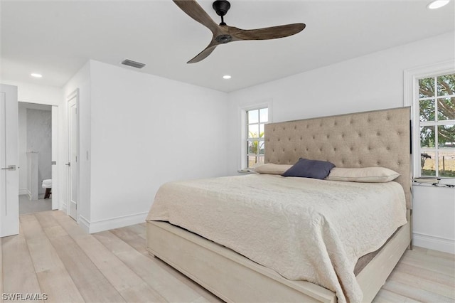 bedroom with connected bathroom, ceiling fan, and light hardwood / wood-style flooring