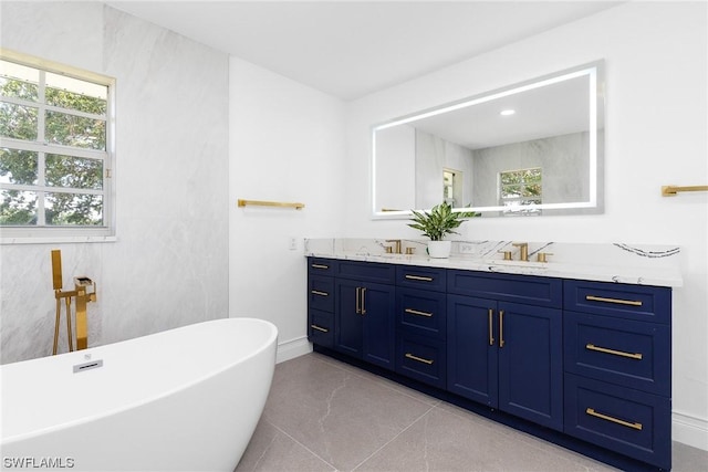 bathroom featuring vanity, tile patterned floors, a wealth of natural light, and a tub