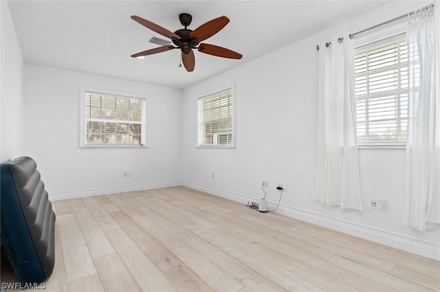 spare room with ceiling fan, plenty of natural light, and light hardwood / wood-style floors