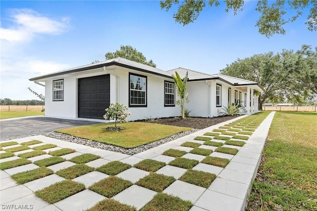 single story home with a front yard and a garage