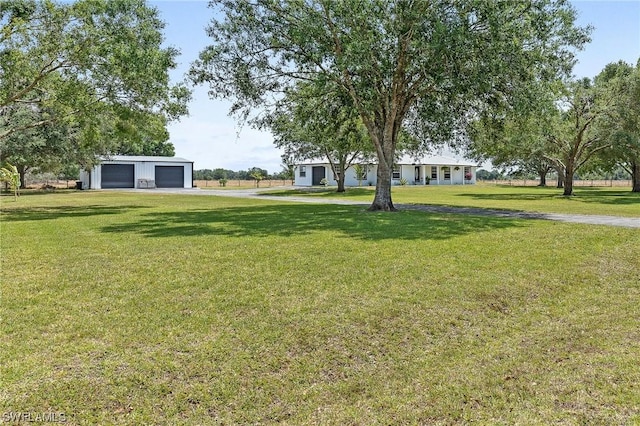 view of yard featuring a garage and an outbuilding