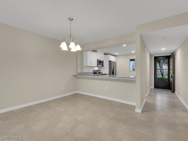 kitchen with white cabinetry, kitchen peninsula, a chandelier, decorative light fixtures, and appliances with stainless steel finishes