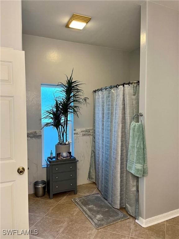 bathroom with walk in shower and tile patterned flooring