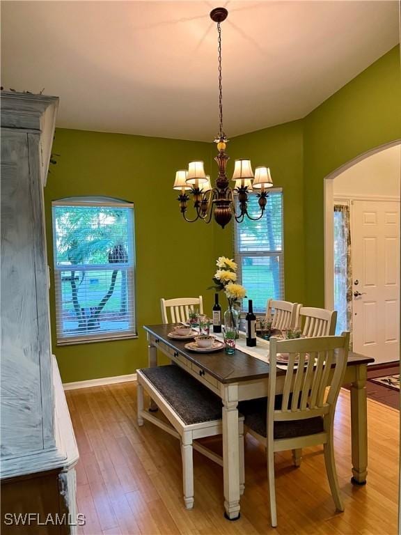 dining space featuring hardwood / wood-style flooring and a notable chandelier