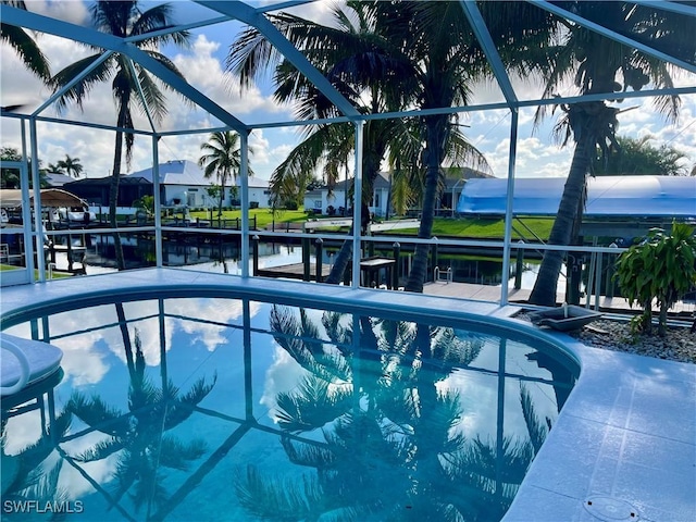 view of swimming pool featuring a water view and a lanai