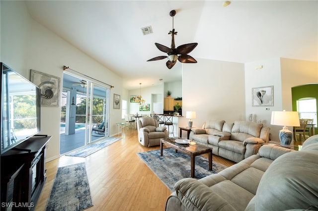 living room with ceiling fan, light wood-type flooring, and lofted ceiling