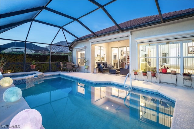 view of pool with glass enclosure, an in ground hot tub, and a patio area