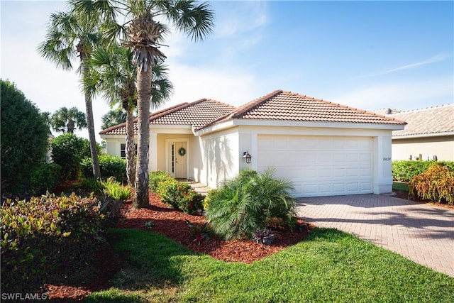 10038 Oakhurst Way, Fort Myers, FL 33913 - mediterranean / spanish-style house featuring a tiled roof, an attached garage, stucco siding, and decorative driveway