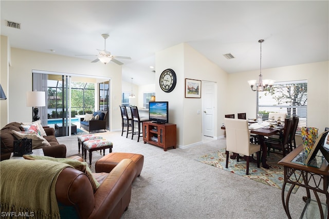 living room with ceiling fan with notable chandelier, vaulted ceiling, and light colored carpet