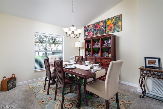 dining room featuring a notable chandelier, vaulted ceiling, and carpet