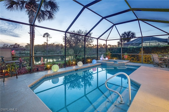 pool at dusk with glass enclosure, an in ground hot tub, and a patio area