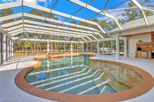 view of pool featuring glass enclosure and a patio