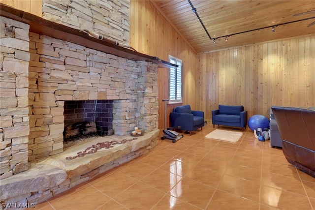 unfurnished living room featuring tile patterned floors, a stone fireplace, wooden walls, and wood ceiling