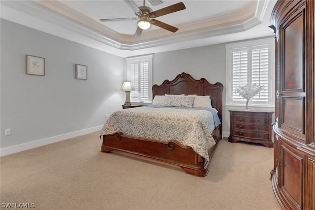 carpeted bedroom featuring ceiling fan, ornamental molding, and a tray ceiling