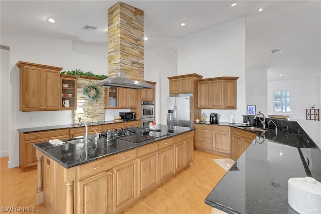 kitchen featuring dark stone counters, sink, an island with sink, and stainless steel appliances