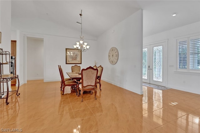 tiled dining room featuring french doors, a chandelier, and lofted ceiling