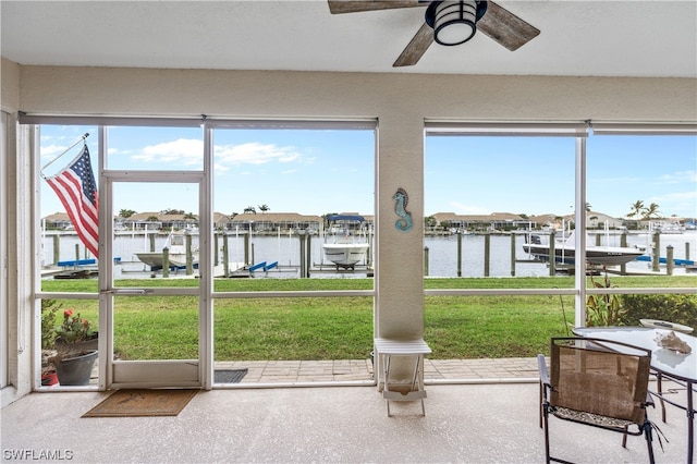 sunroom with a water view, ceiling fan, and plenty of natural light