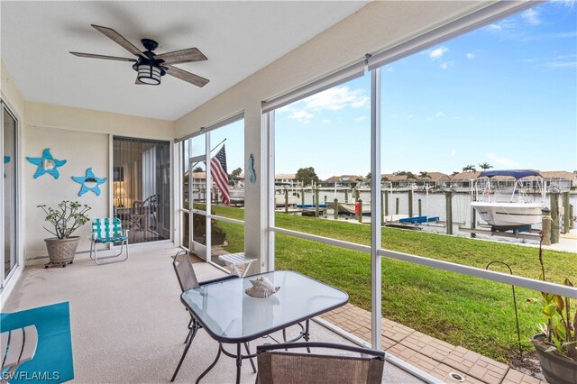 sunroom featuring a water view and ceiling fan