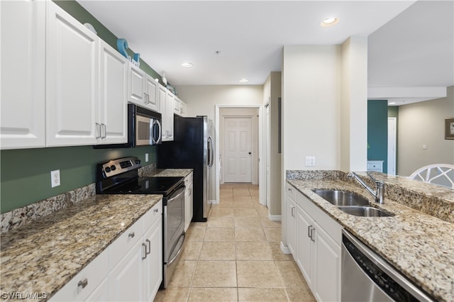 kitchen featuring stainless steel appliances, light tile floors, light stone countertops, white cabinets, and sink