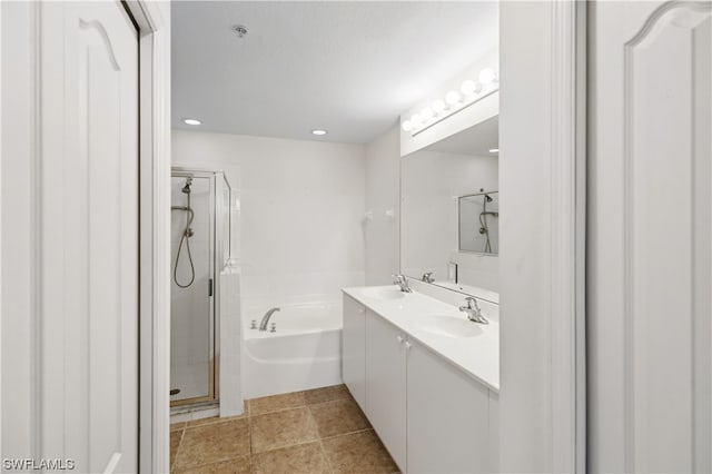 bathroom with dual vanity, a textured ceiling, tile floors, and separate shower and tub