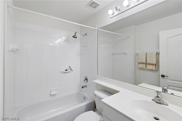 full bathroom featuring tiled shower / bath, toilet, and oversized vanity