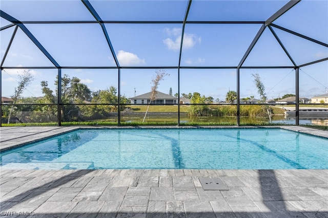 outdoor pool featuring a patio area, a water view, and a lanai