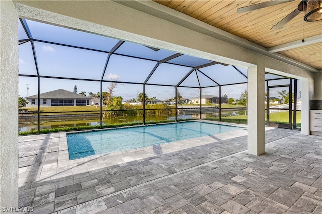 outdoor pool with a ceiling fan, a residential view, a lanai, a water view, and a patio area