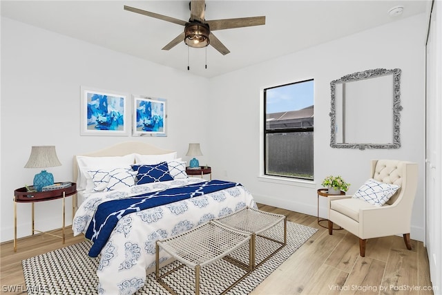 bedroom featuring light wood-style floors, ceiling fan, and baseboards