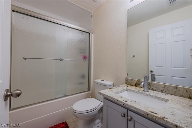 full bathroom with enclosed tub / shower combo, vanity, and toilet