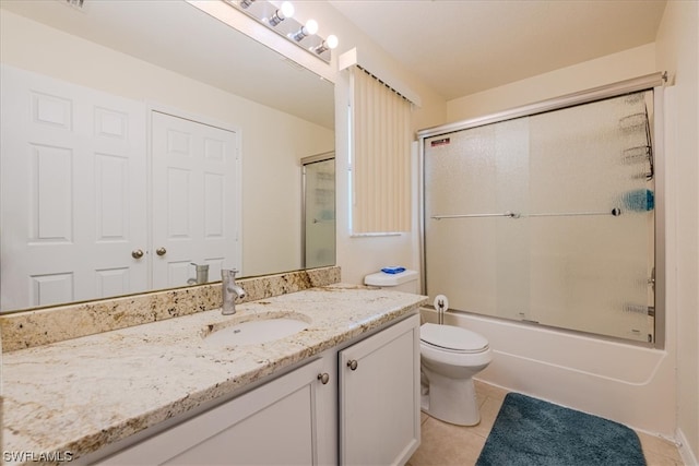 full bathroom featuring toilet, tile patterned floors, shower / bath combination with glass door, and vanity