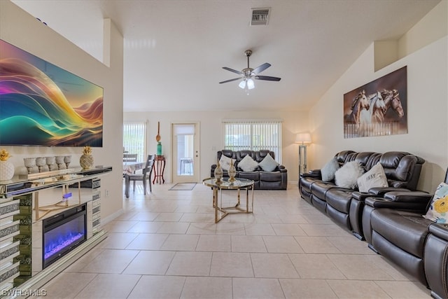 tiled living room featuring ceiling fan, plenty of natural light, and vaulted ceiling