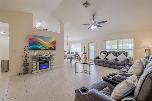 living room featuring lofted ceiling, ceiling fan, and light tile patterned floors