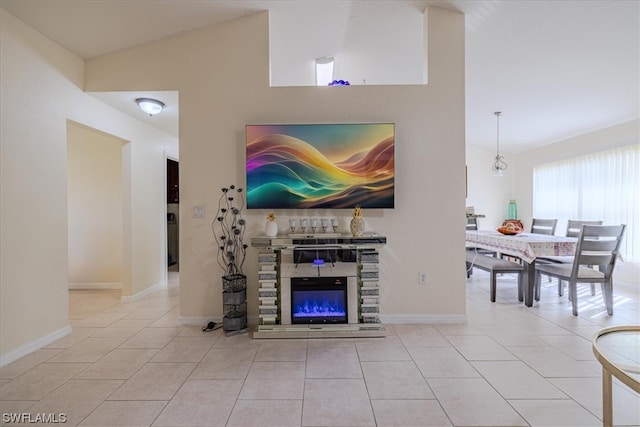 living room featuring light tile patterned floors, vaulted ceiling, and a stone fireplace