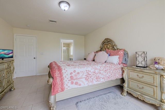 tiled bedroom featuring ensuite bath