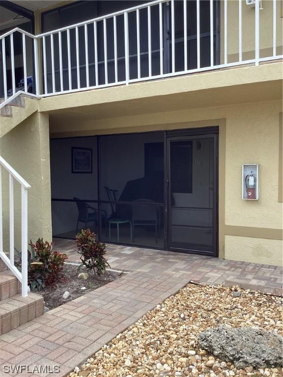 view of exterior entry with a patio and a balcony