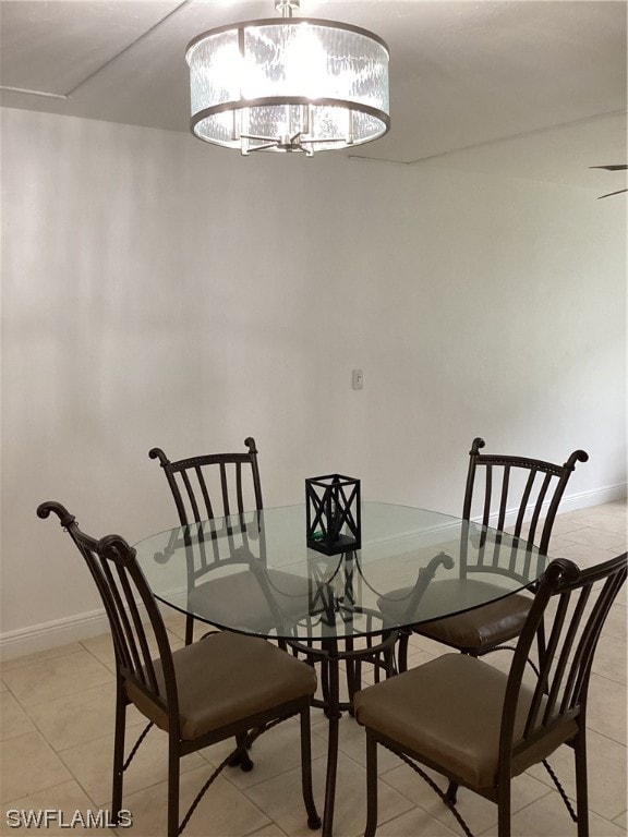 dining space featuring an inviting chandelier and light tile floors