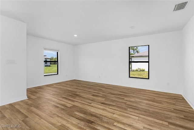 unfurnished room with a healthy amount of sunlight and light hardwood / wood-style flooring