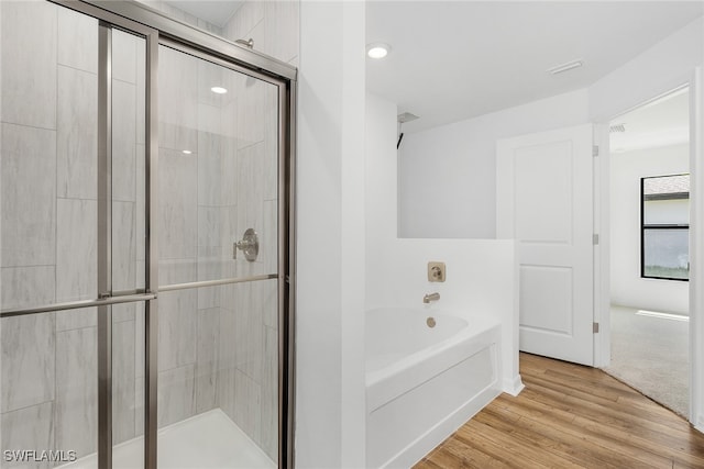 bathroom with wood-type flooring and plus walk in shower