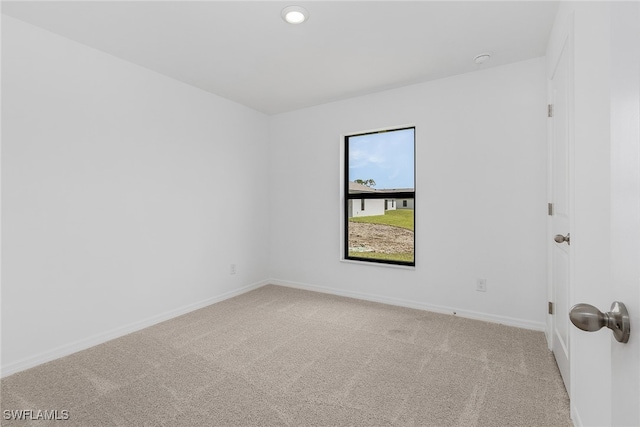 spare room featuring light colored carpet