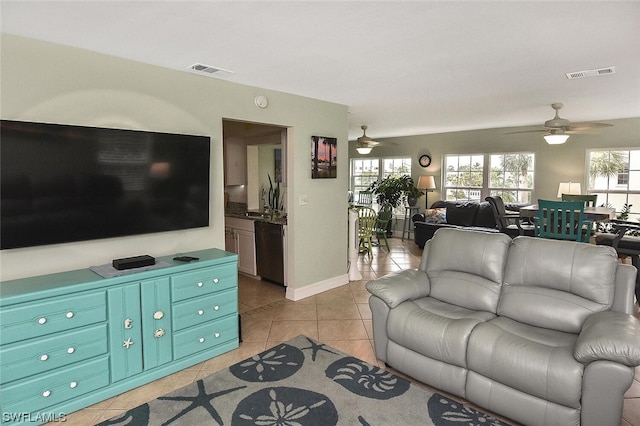 tiled living room featuring ceiling fan and sink